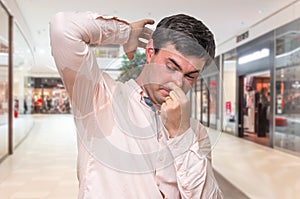 Man with sweating under armpit in shopping center