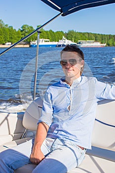Young man swiming and resting on his yacht at