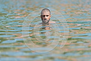 Young Man Swimming In Green Water