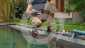 Young man swimming pool serviceman checking chlorine, PH and other chemical levels