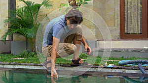 Young man swimming pool serviceman checking chlorine, PH and other chemical levels