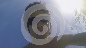 Young man swimming underwater in sunglasses in amazing blue ocean on sunny summer day. slow motion. 1920x1080