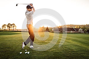 Young man swinging at golf course