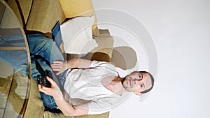 Young man switch at living room. Home vacation sofa portrait. Watch tv video