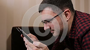 Young man with tablet computer lying on sofa read funny news