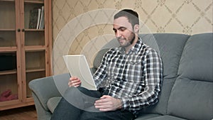 Young man with tablet pc computer having video call at home