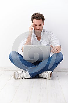 Young man in tailor seat browsing internet