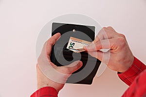 Young man takes out folded in half euro banknotes from a purse, business concept, purchase, cash