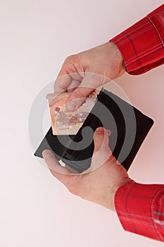 Young man takes out folded in half euro banknotes from a purse, business concept, purchase, cash