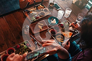 Young man takes a picture of his food for social network while having breakfast in cafe. Internet addiction concept. photo