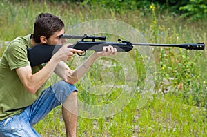 Young man taking aim with the air rifle
