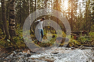 Young man taking off clothes while standing on the bank of the river