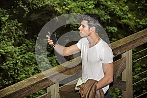 Young Man Taking Selfie with Cell Phone in Forest