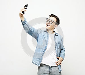 young man taking a selfie isolated over white background