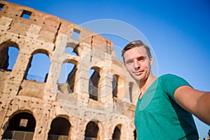 Young man taking selfie portrait in front of Colosseum in Rome, Italy