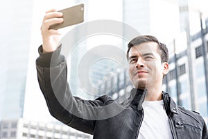 Young man taking selfie with smartphone