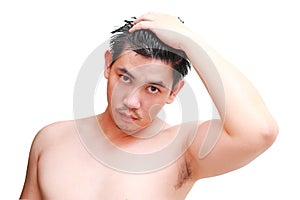 Young man taking a shower and standing under flowing water in bathroom