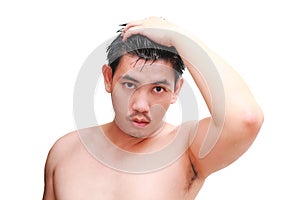 Young man taking a shower and standing under flowing water in bathroom