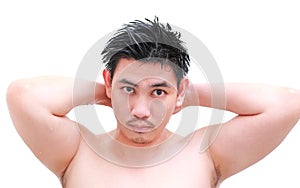 Young man taking a shower and standing under flowing water in bathroom