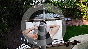 Young man talking on cellphone on hammock