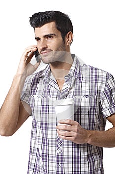 Young man talking on mobilephone drinking coffee