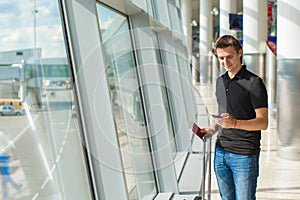 Young man talking on phone inside the airport