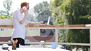 Young Man Talking on Phone, Standing in Balcony Outdoor