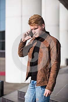 Young man talking on the phone, using smartphone, making a call.