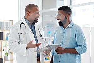 Young man talking to his doctor about his test results. Medical professional talking to a patient about their chart