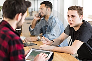 Young man talking to a stockbroker about investing in digital mo