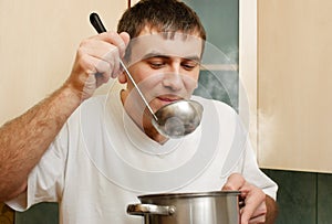 Young man tastes food photo