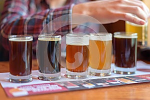 Young man tasting beer samples from a beer flight