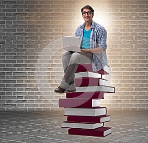 Young man in telelearning concept with laptop and books