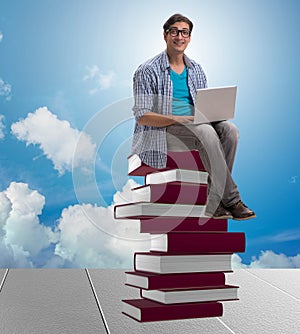 Young man in telelearning concept with laptop and books