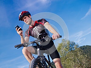 Young man with telephone riding mountain bike