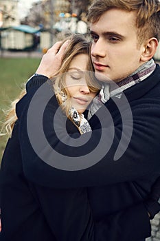 Young man tenderly embracing his girlfriend, feeling comfortable together.