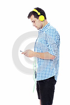 Young man texting on his phone and listening to music. Isolated on white background. Copy space. Mock up. Student chatting