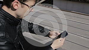 Young man texting on smartphone in cafe.