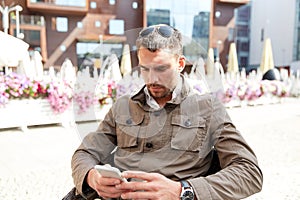 Young man texting on smartphone at city terrace