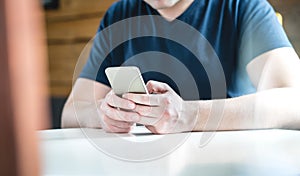 Young man texting with smartphone. Guy using mobile phone. photo