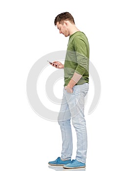 Young man texting on smartphone over white