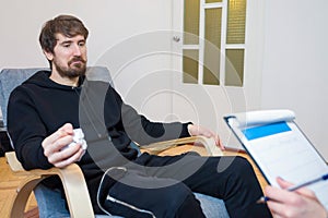 Young man during therapy in a psychologists office. Psychotherapy, psychology, concept of help and support