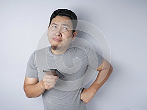 Young Man Thinking While Chatting on Smart Phone