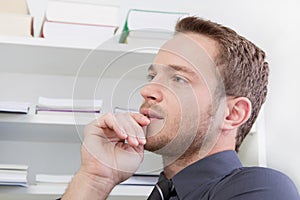 Young man thinking at office.