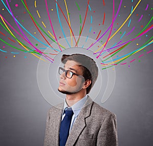 Young man thinking wiht colorful abstract lines overhead