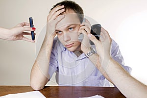 Young man with three cellphones