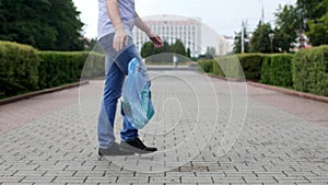 A young man throws out a package of garbage in the center of the city, litterbug