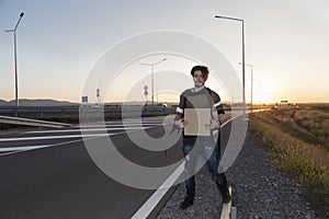 Young man thumbing on a road