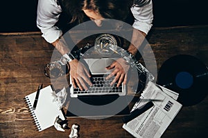 Young man with tied hands using laptop with blank screen