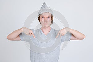 Young man with tin foil hat pointing at shirt